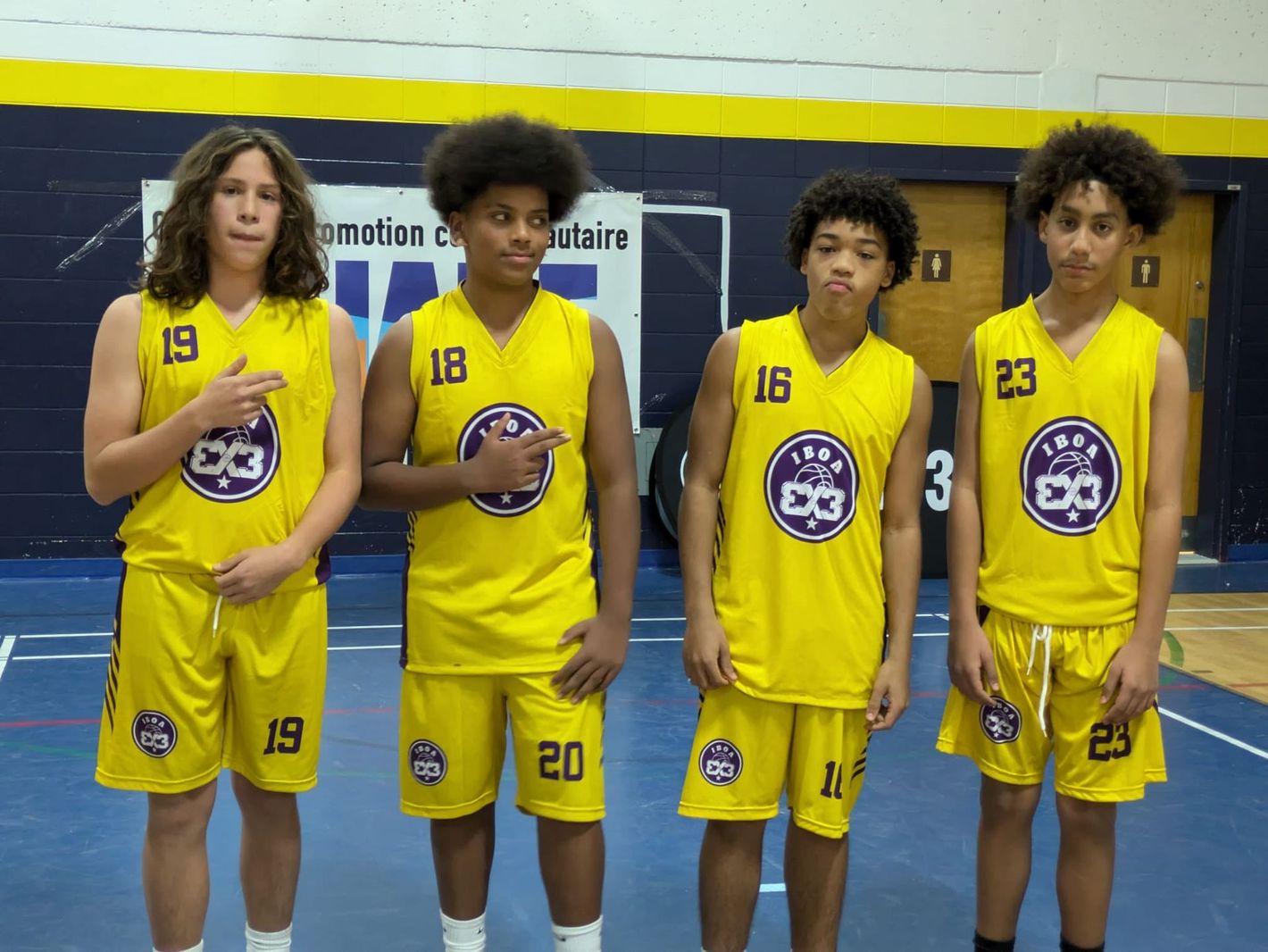 IBOA 3x3 youth players wearing yellow uniform lined up on the court during an event.
