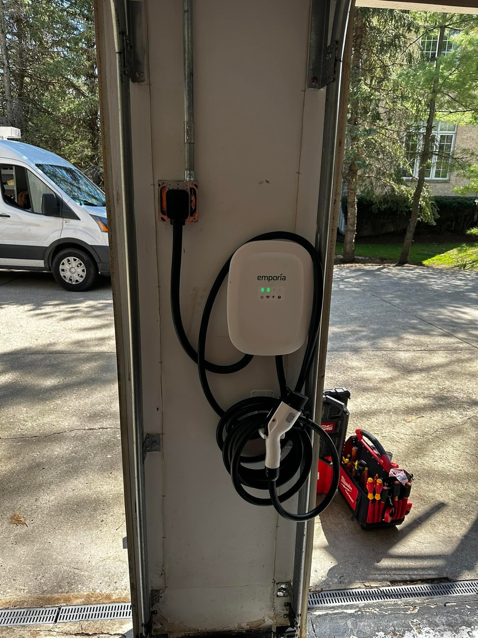 A car is being charged at a charging station in a garage.