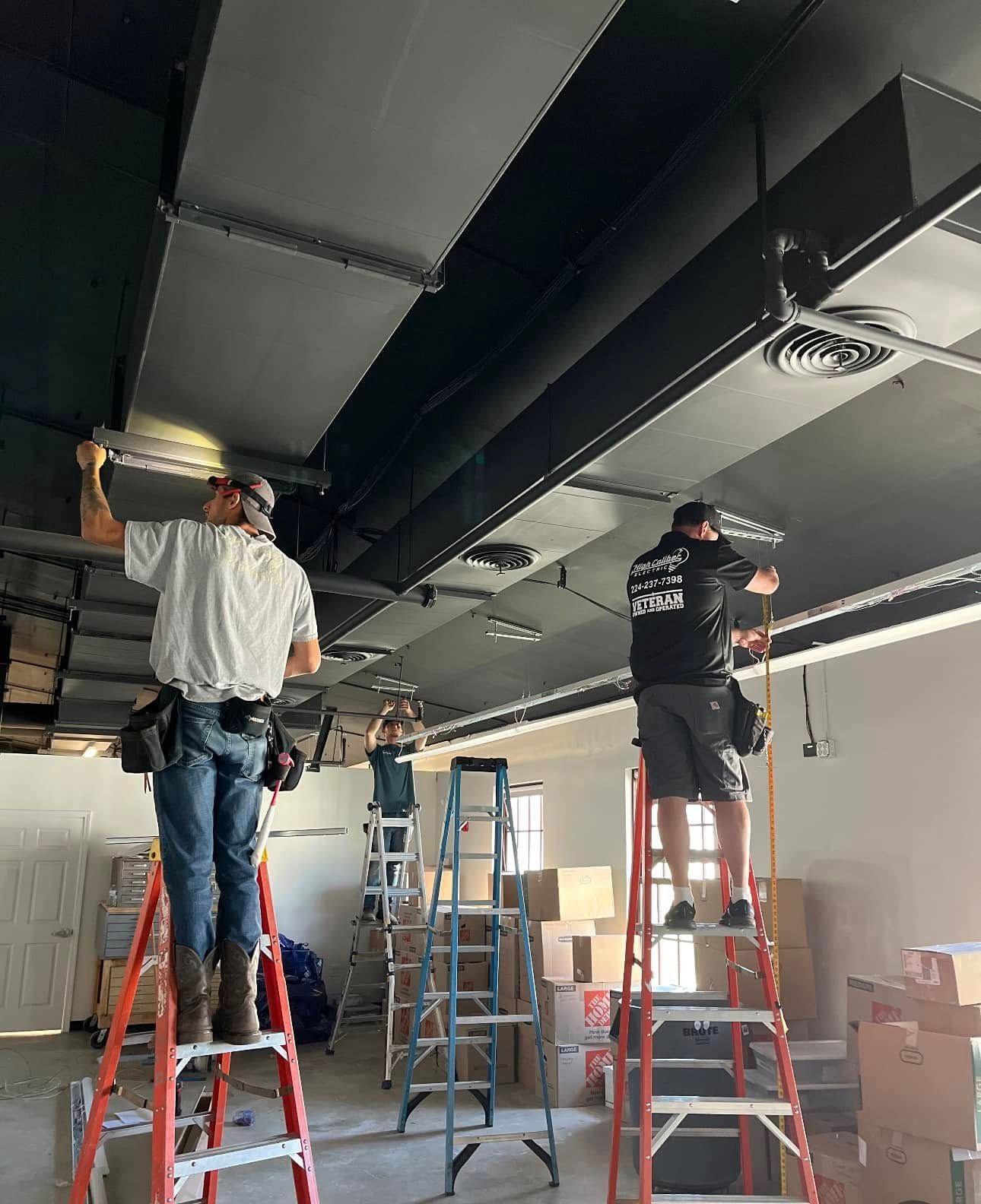 A group of men are working on the ceiling of a building.