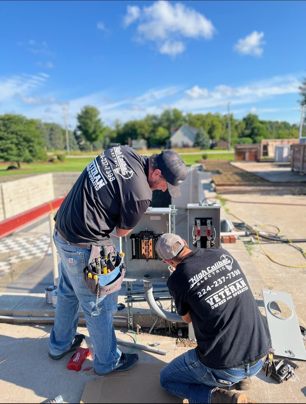 Two men are working on a machine on a roof.