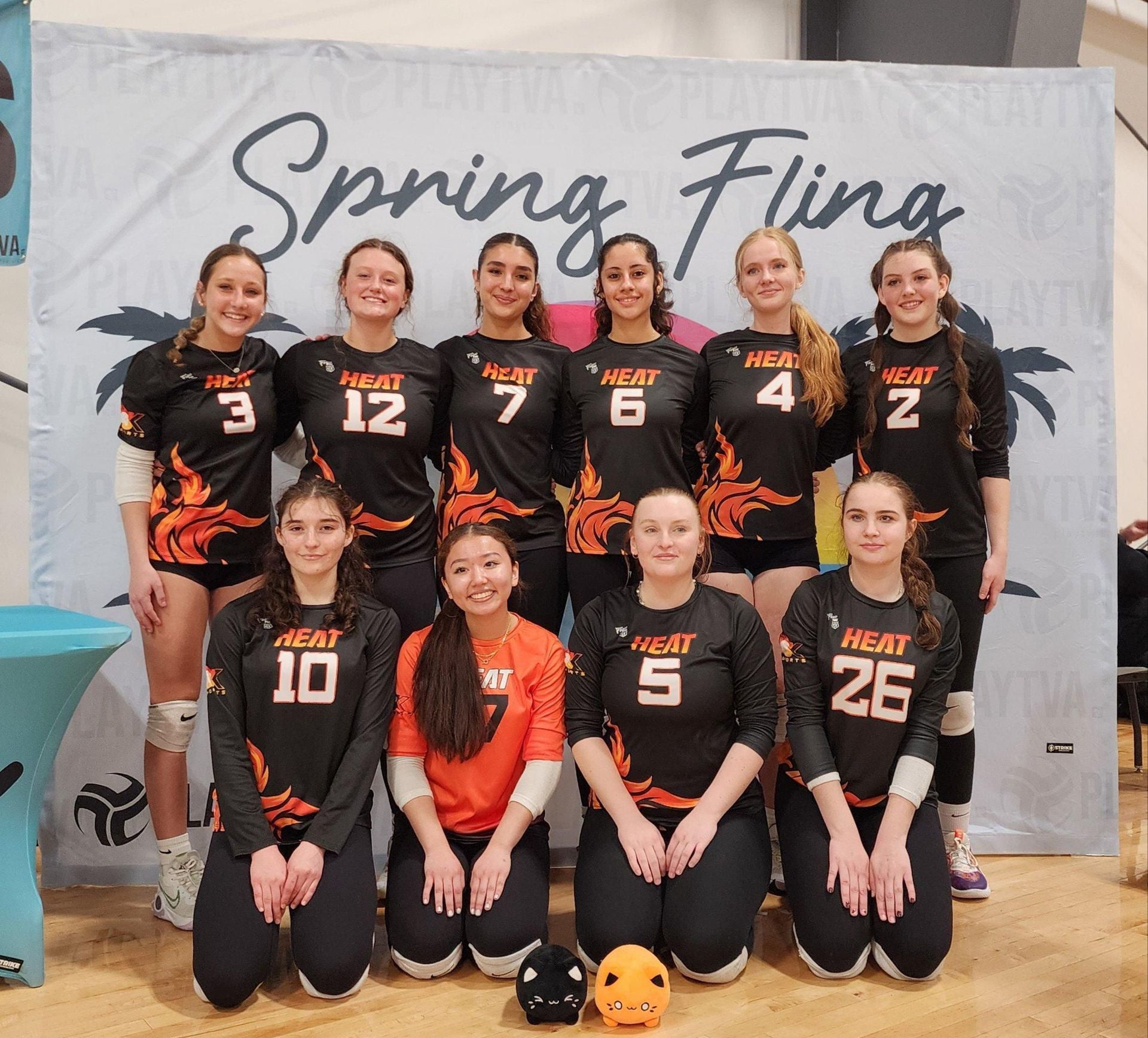 A group of women are posing for a picture in front of a banner that says spring fling