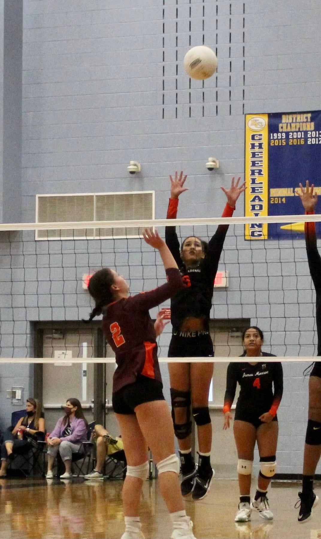 A volleyball game is being played in front of a banner that says castle cup