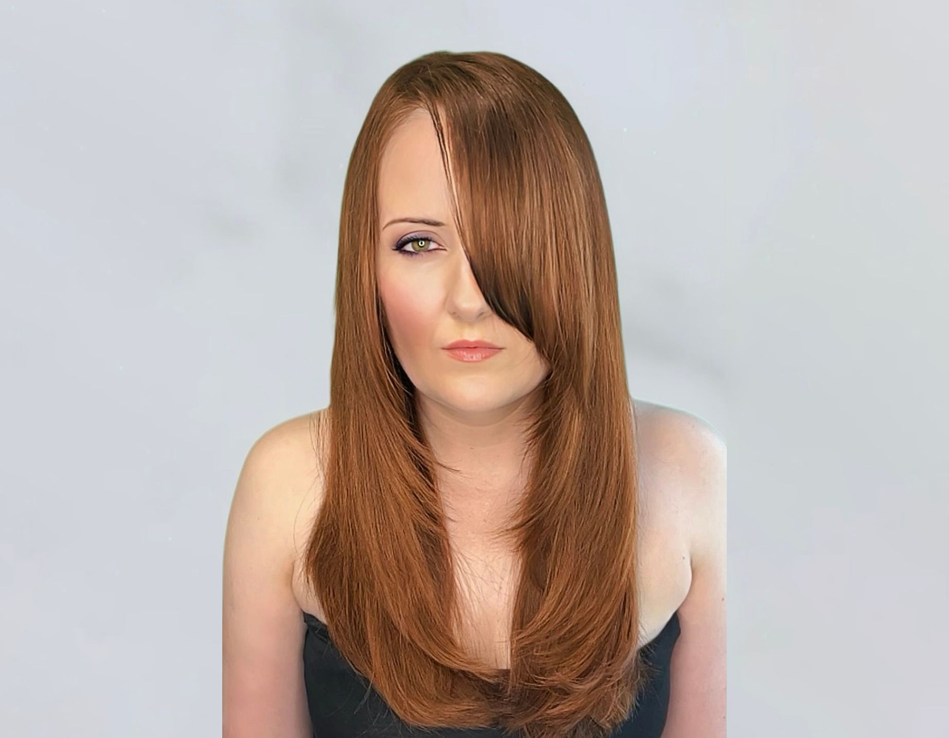 Front view of client who was tossing her long flowing brunette hair, now hanging down straight on both sides of her face.