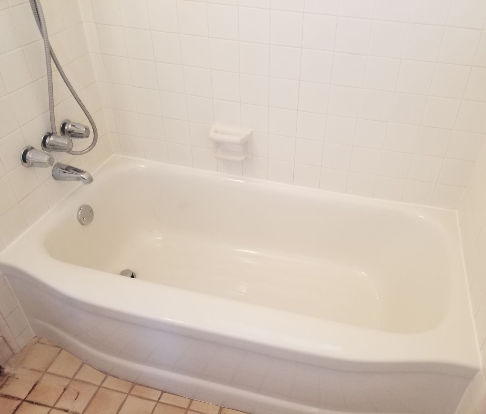 Modern kitchen with light wood cabinets, white countertops, and stainless steel range hood.