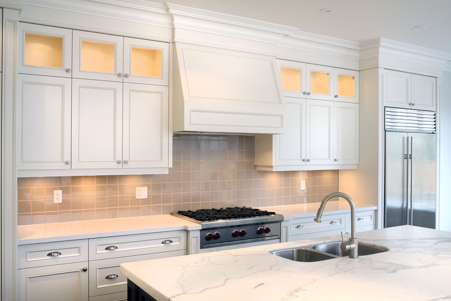 White kitchen with cabinets, countertops, and stainless steel appliances.