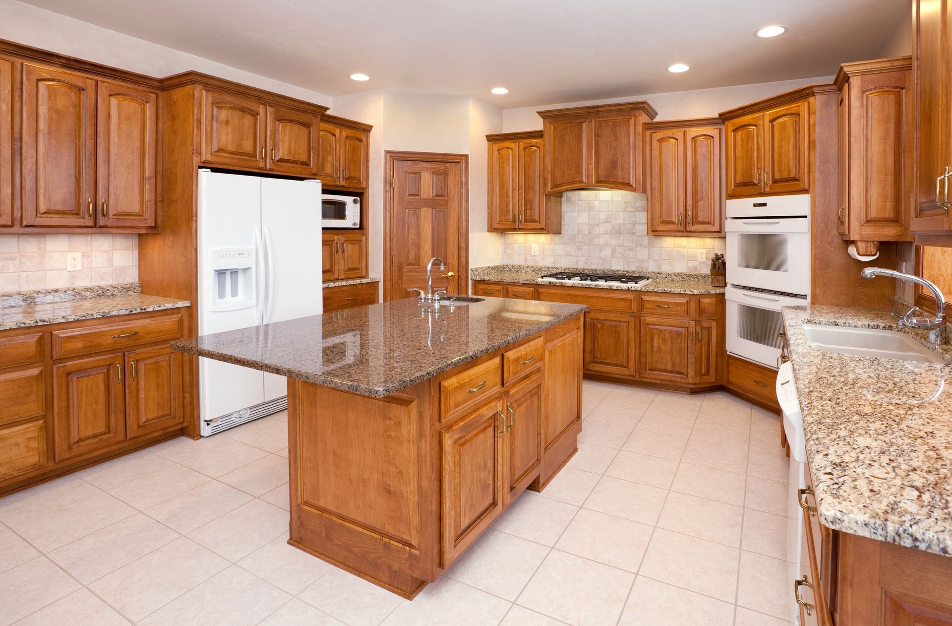 Kitchen with brown cabinets, granite countertops, stainless steel appliances, and an island.