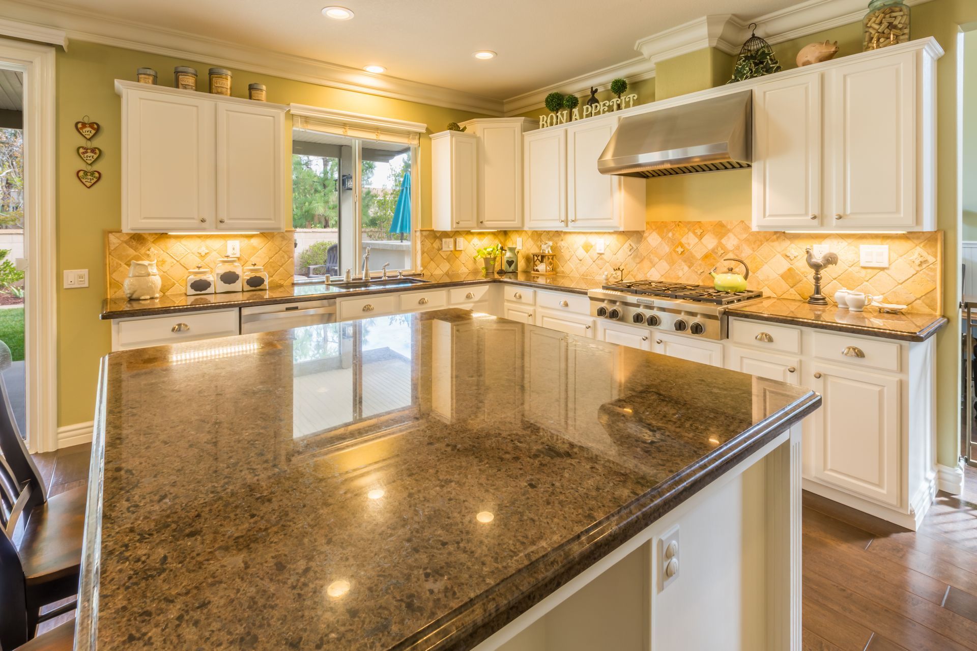 Spacious kitchen with white cabinets, granite countertops, and stainless steel appliances.