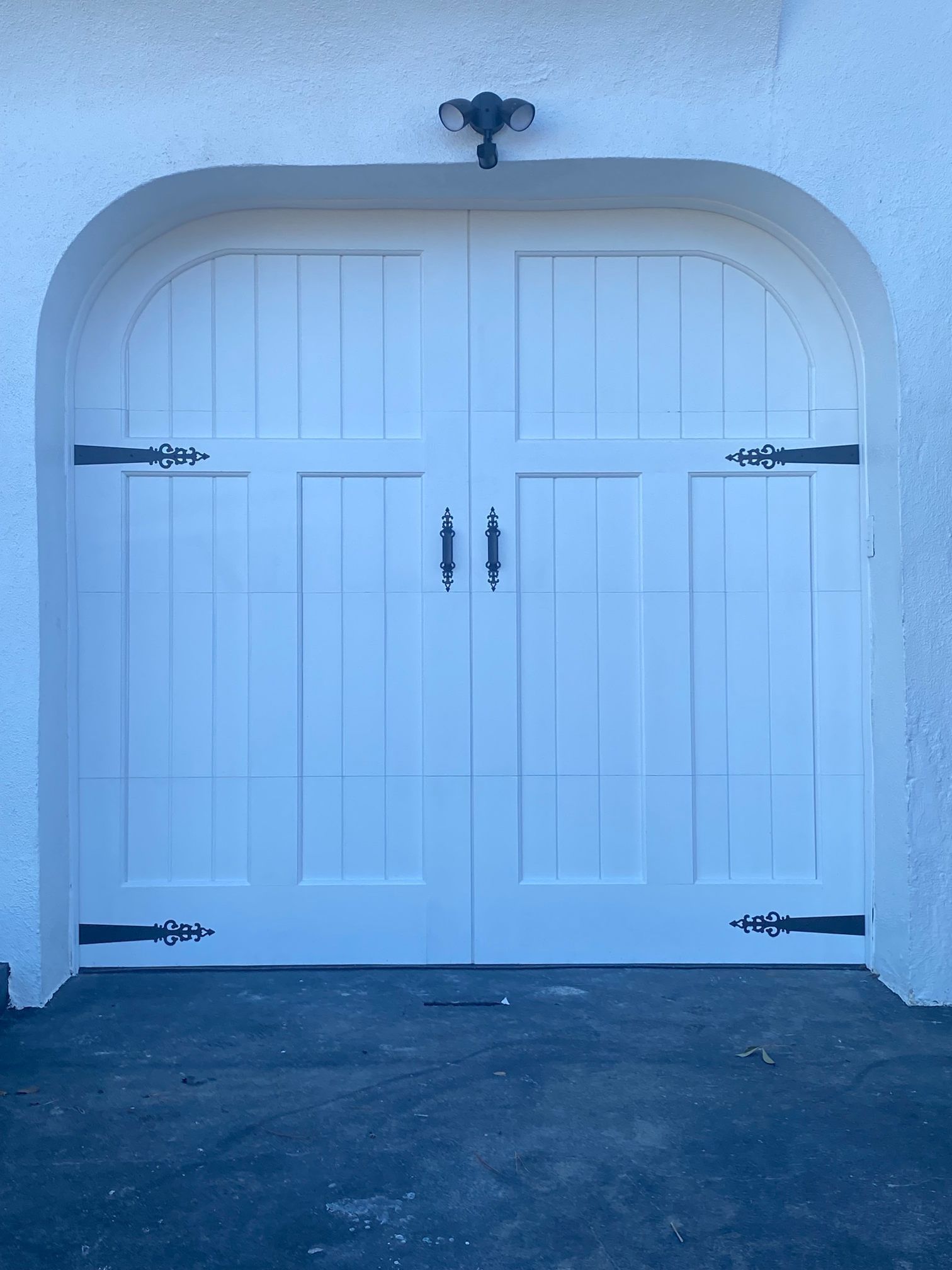 A white garage door is open on a brick building.
