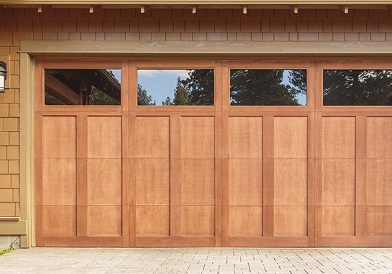 The garage door is made of wood and has a lot of windows.