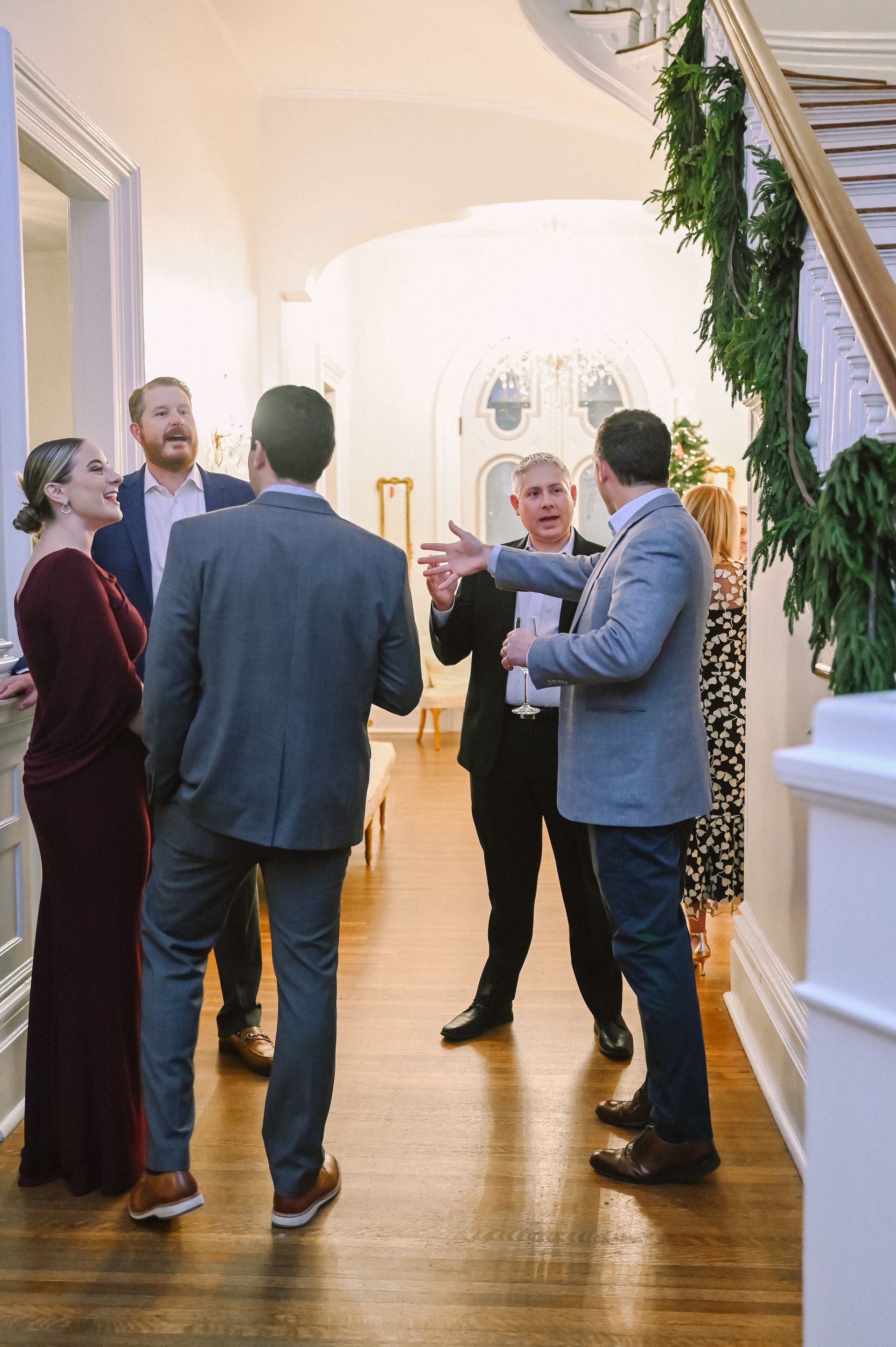 Group of coworkers in the foyer at a Corporate Event Holiday Party at The Merrimon-Wynne House in Raleigh, NC. 