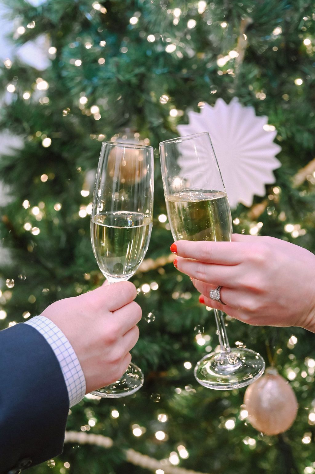 Two glasses of champagne clinking at a Corporate Event Holiday Party at The Merrimon-Wynne House in Raleigh, NC.