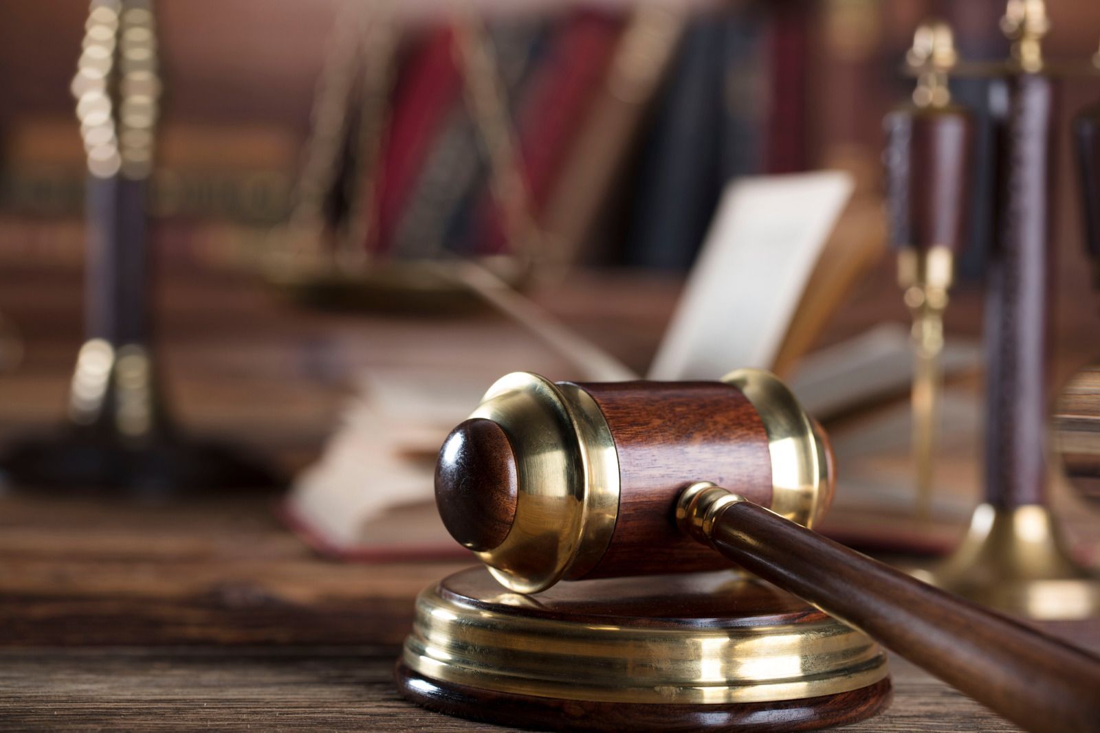 A wooden judge 's gavel is sitting on a wooden table.
