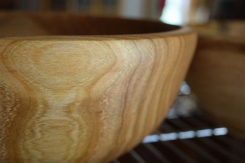 A close-up of a hand made wooden bowl on a table.