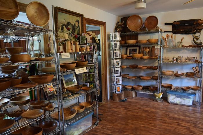 A room filled with shelves filled with hand made wooden bowls and plates in East Burke, Vermont.