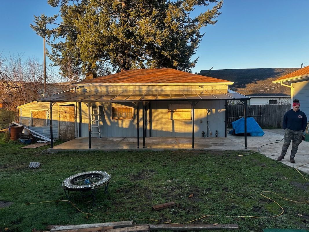 A man is standing in front of a house in a backyard.