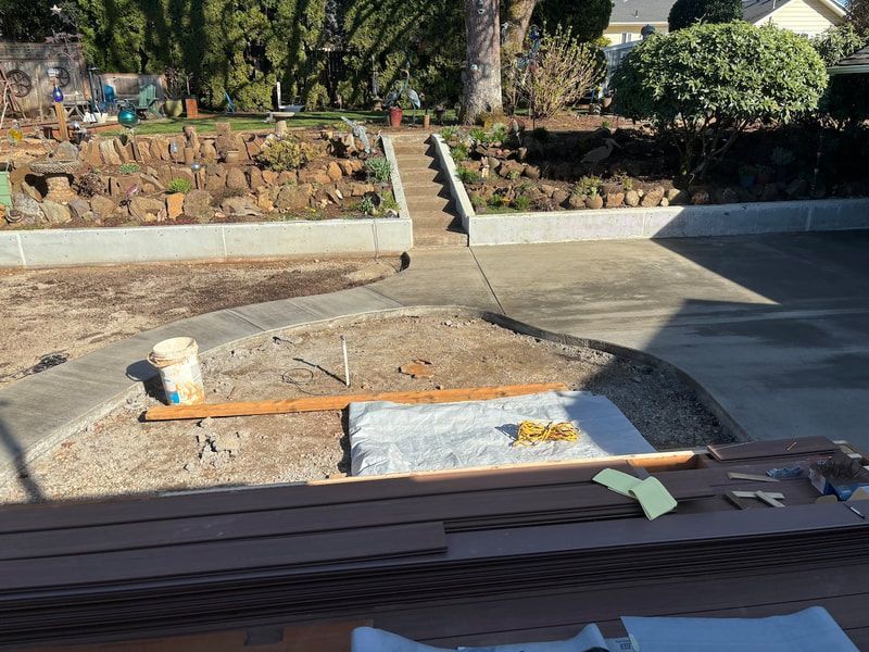 A wooden table is sitting in front of a concrete driveway.