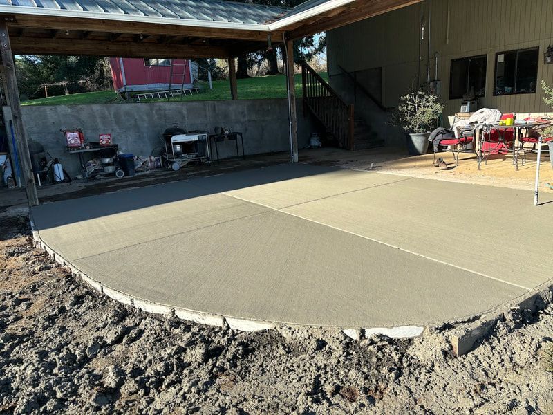 A concrete patio is being built in front of a house.