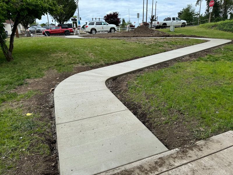 A concrete sidewalk is being built in a park.