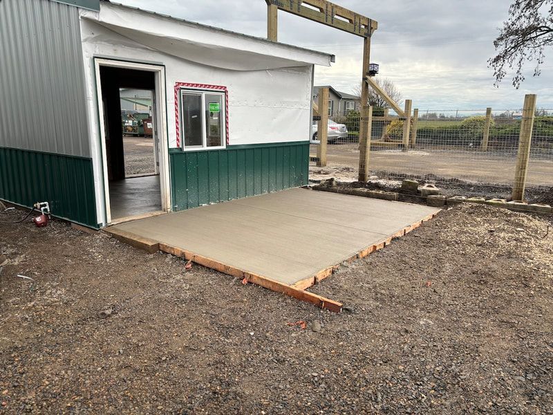 A small building with a concrete floor in front of it is being built.