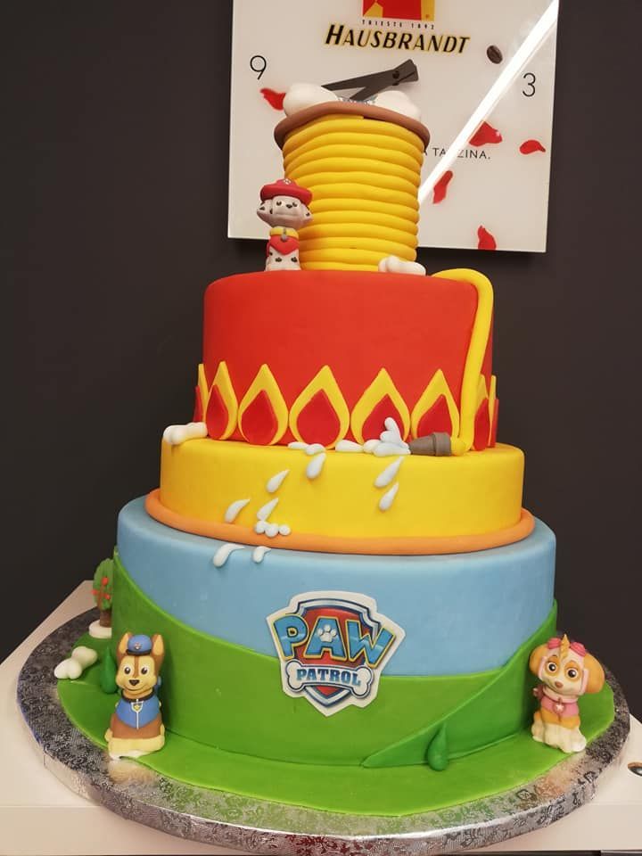 Torta a tre piani della Paw Patrol con Chase, Skye e decorazione a tema fuoco. Colori blu, giallo e rosso.