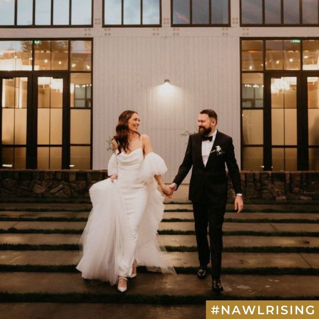 A bride and groom walking down steps outside a building.