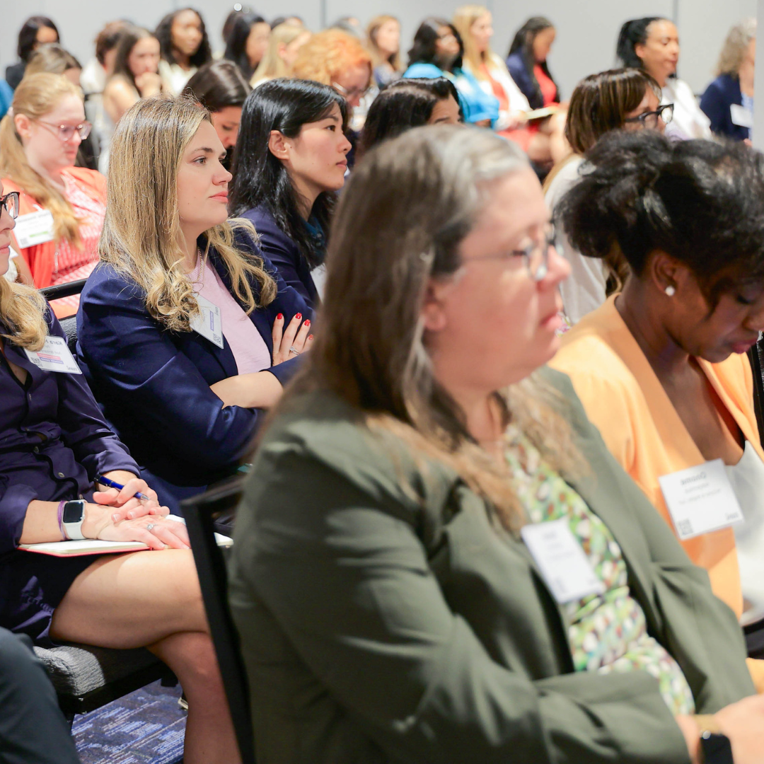 An audience sits in rows at a presentation.