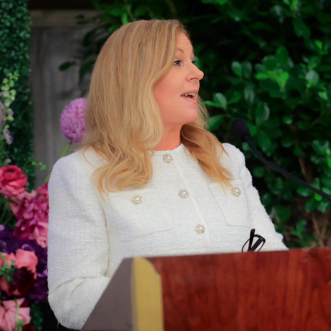 Gigi Rollini speaks at a podium