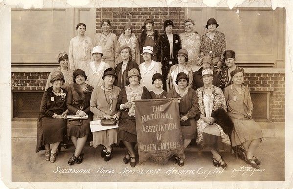 A group of women hold a banner that reads 