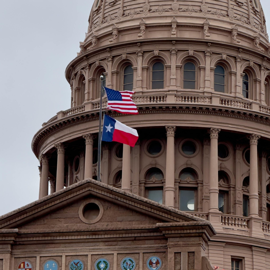 Texas State Capitol dome with American and Texas flags flying