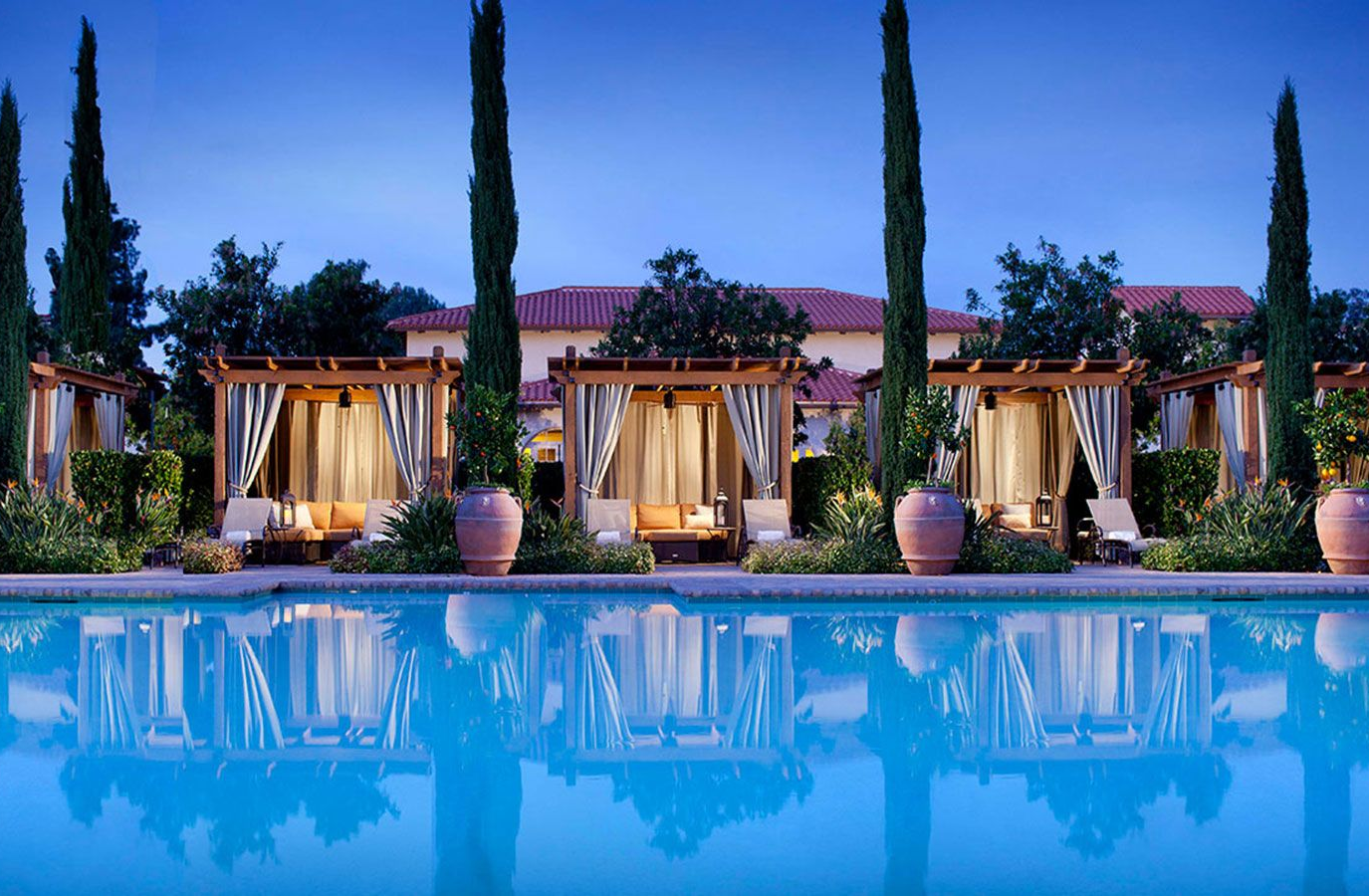 Swimming pool with trees and cabanas.
