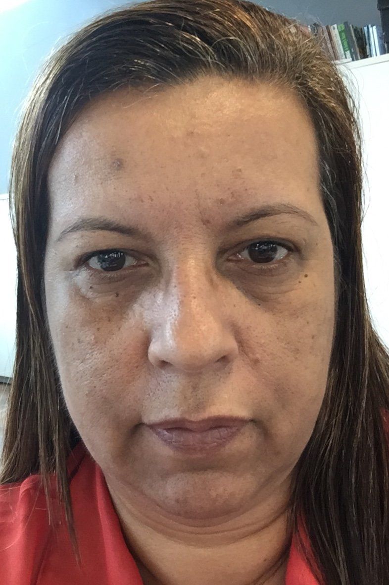 Um close do rosto de uma mulher com uma camisa vermelha.