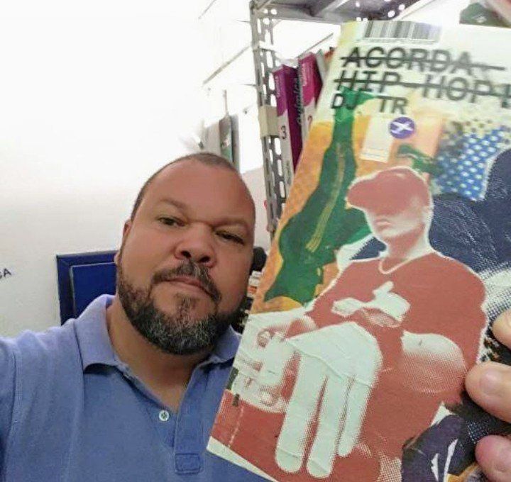 Um homem com barba está segurando um livro que diz agora hip hop