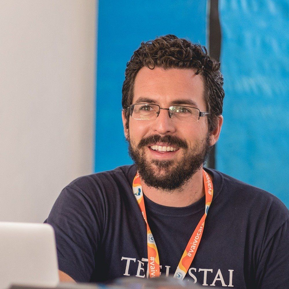 Um homem usando óculos e um cordão que diz tei stai