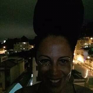 Uma mulher com um grande coque na cabeça está sorrindo para a câmera.