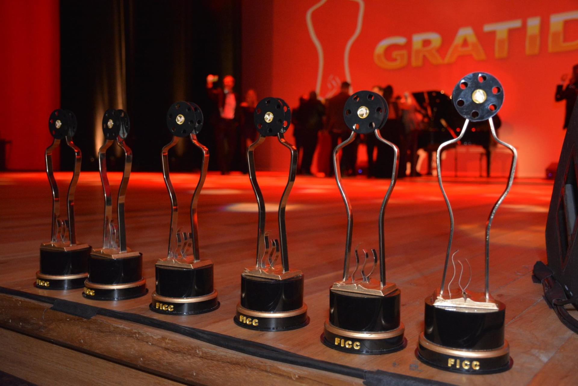 Uma fileira de troféus em um palco com a palavra gratis ao fundo