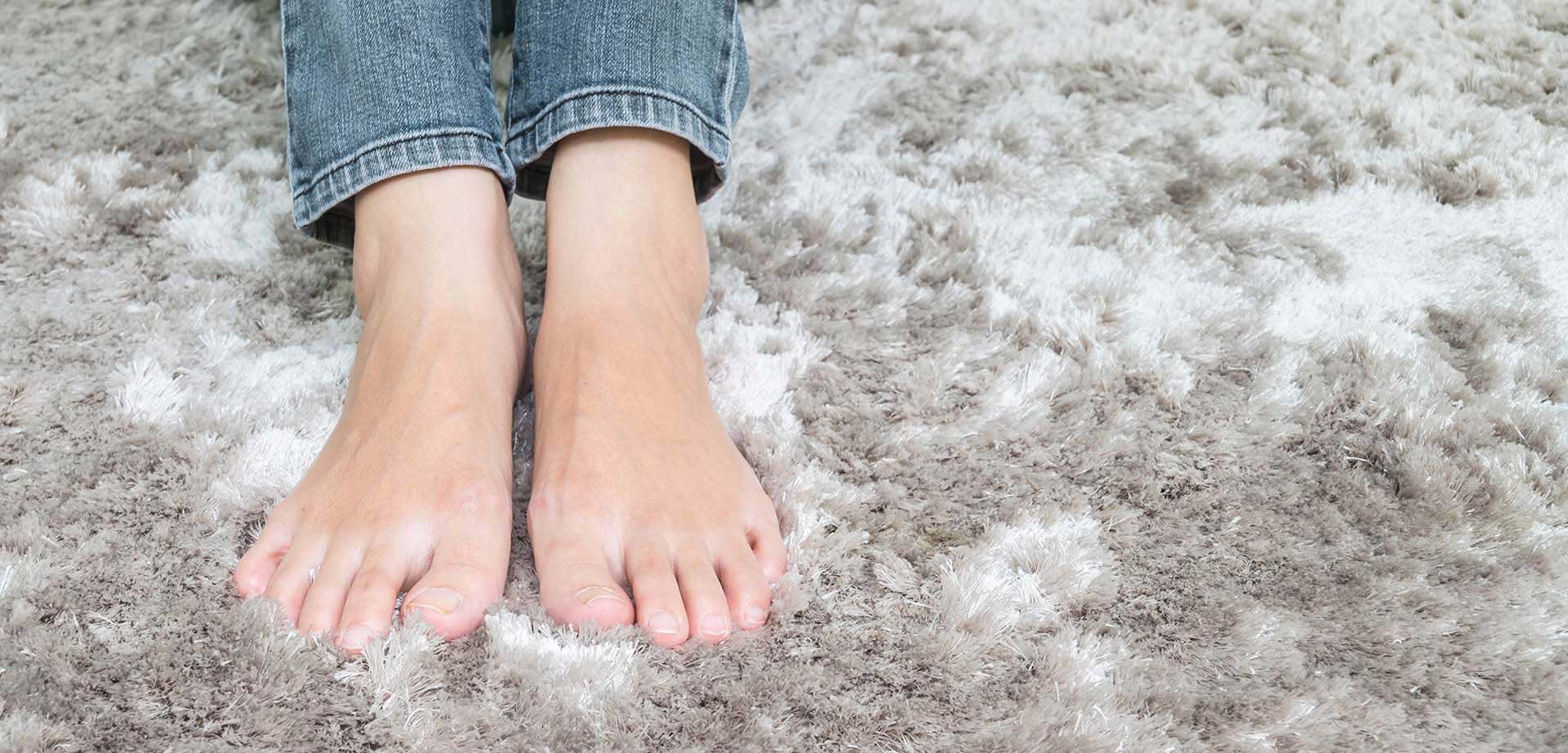 A person's bare feet resting on a cleaning.