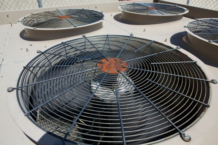 A close up of a fan on top of a building