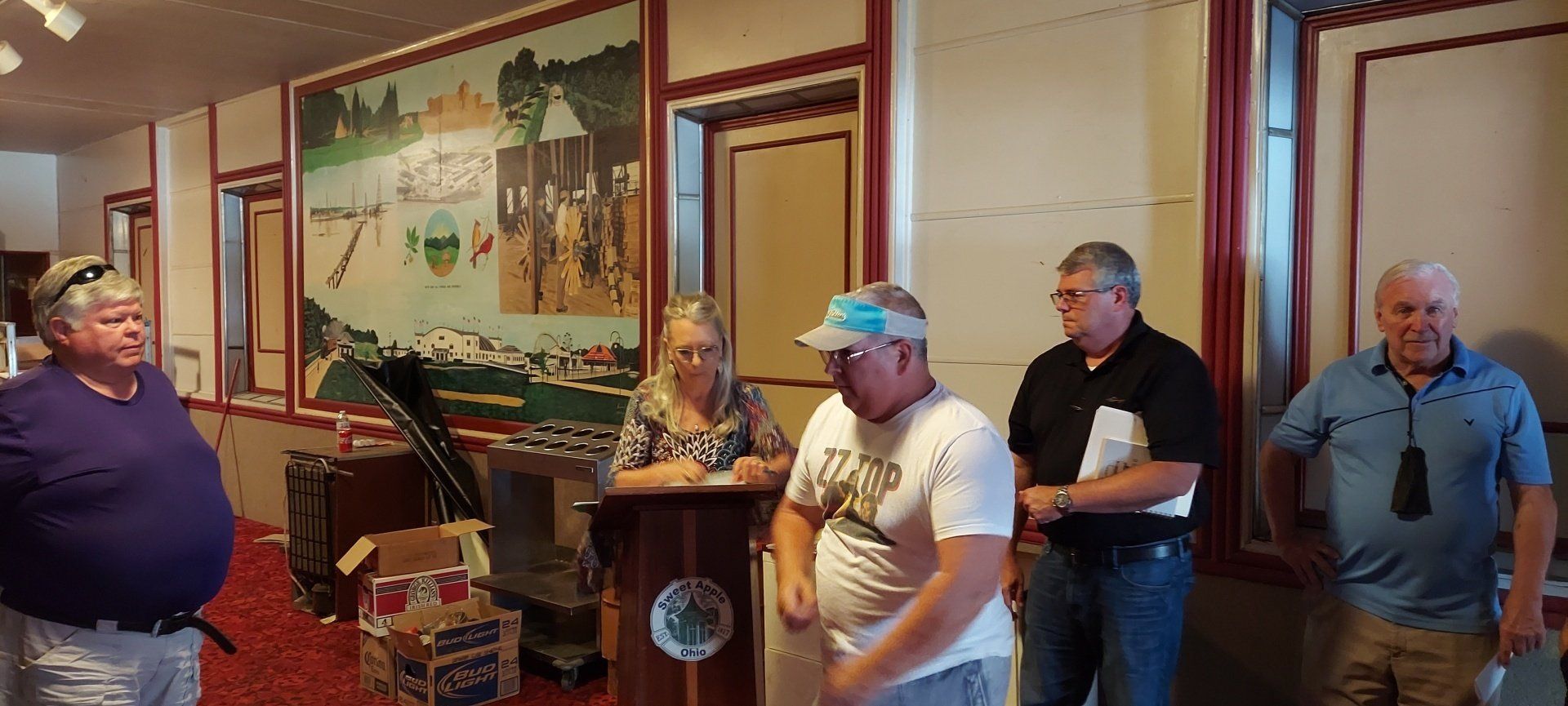 A group of men are standing around a podium in a room.