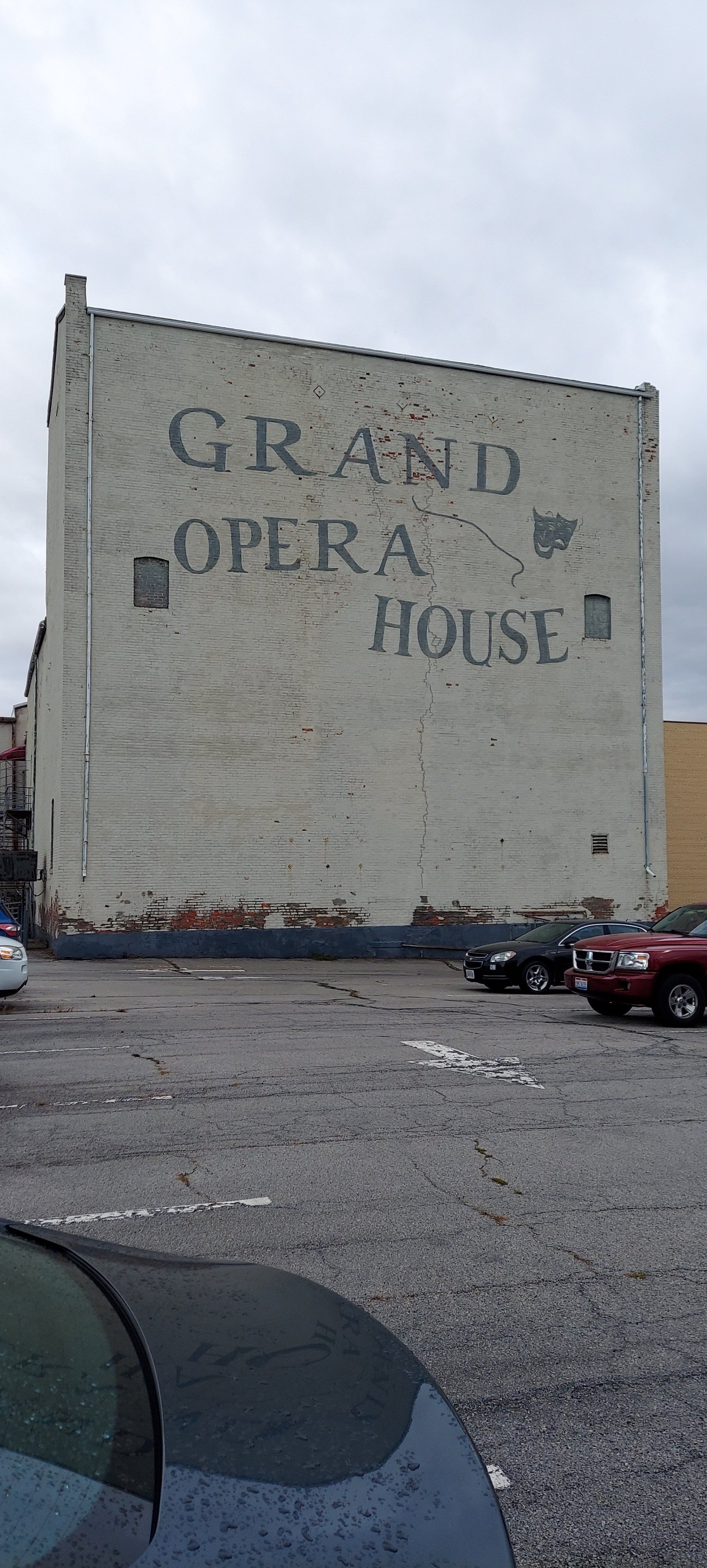 A large white building with the words grand opera house painted on it