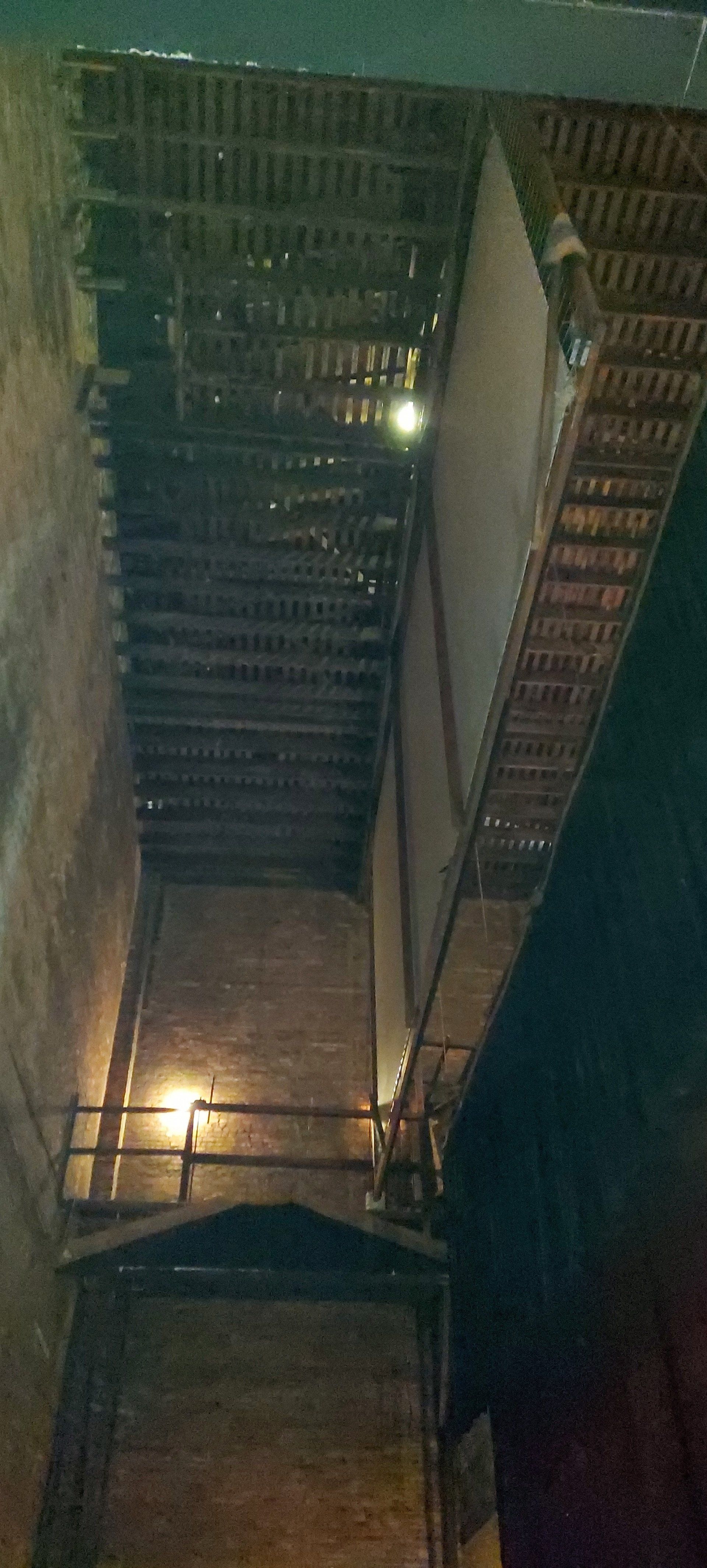 Looking up at a staircase in a building at night.
