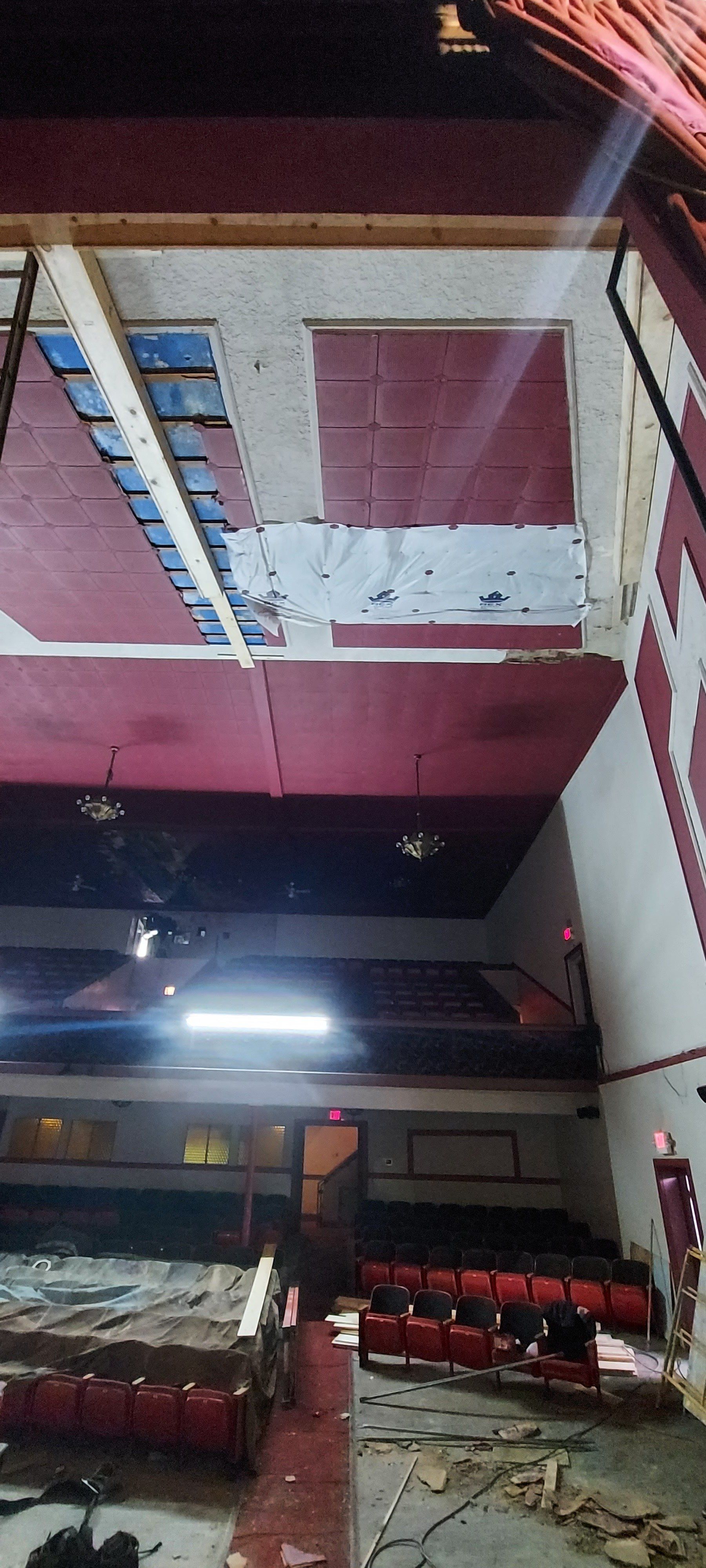 An empty auditorium with red seats and a red ceiling.