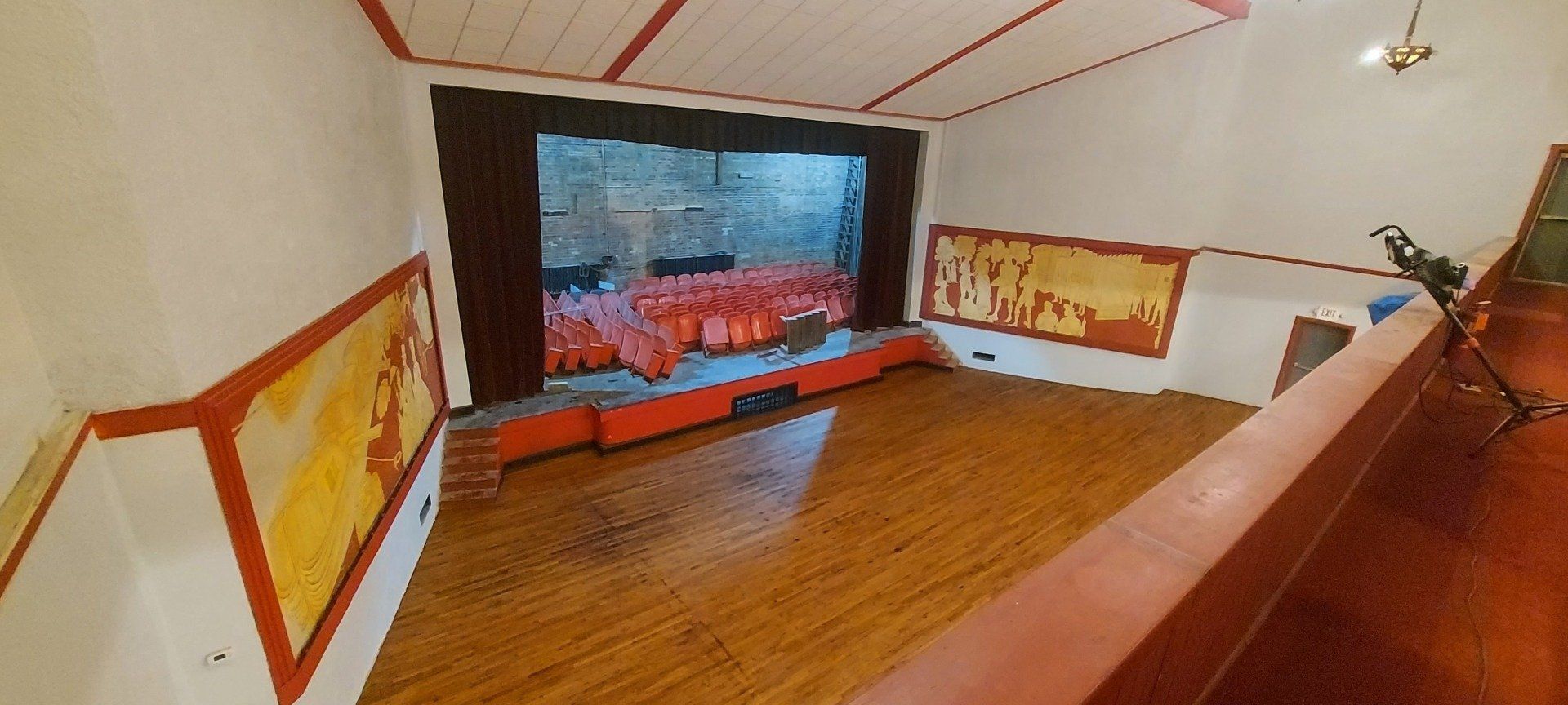 An empty room with a wooden floor and a stage.