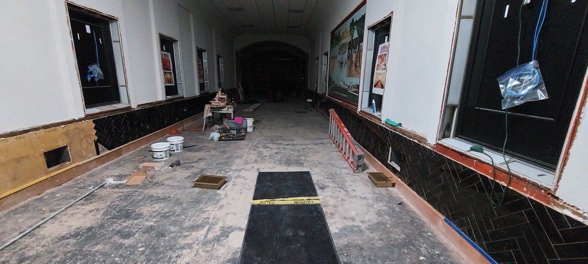A long hallway with a black mat on the floor.