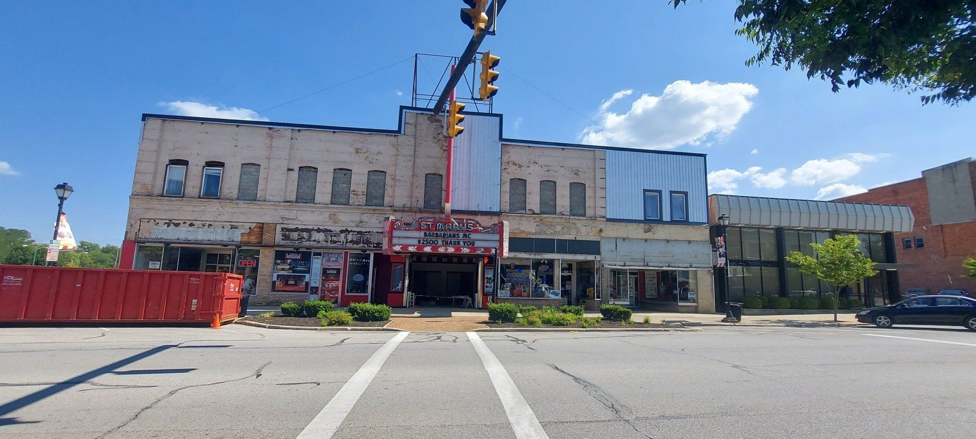 A large building is sitting on the corner of a city street.