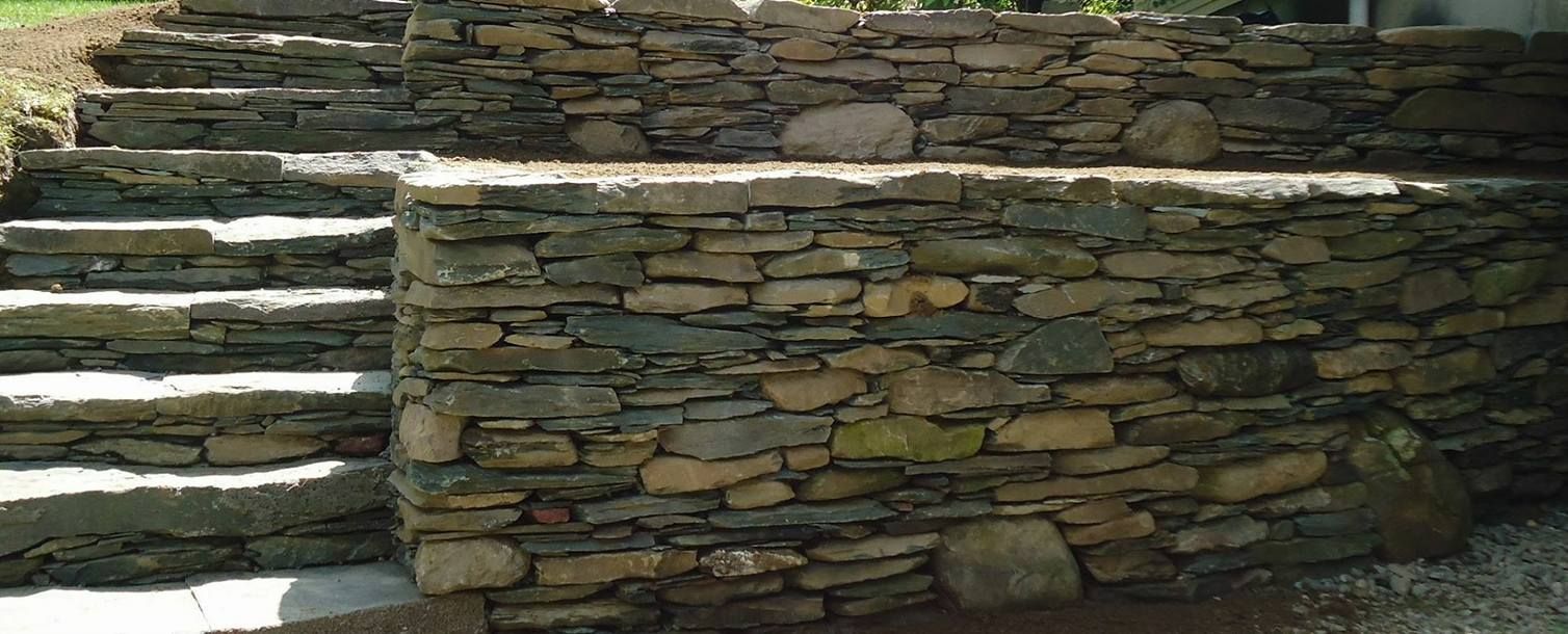 Stone steps leading up a retaining wall.