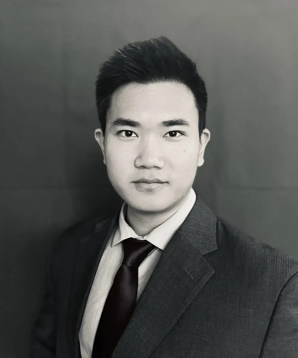 Man in a suit and tie, looking directly at the camera. Black and white photo.