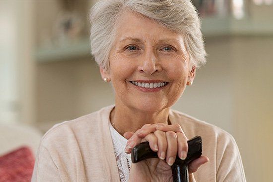 Smiling older woman visiting dentist for full mouth restoration