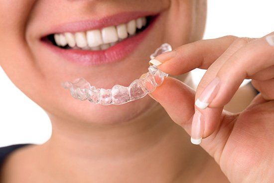 Woman with gorgeous smile holding invisalign