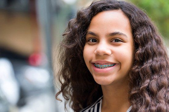 Young Hispanic teen smiling with metal braces