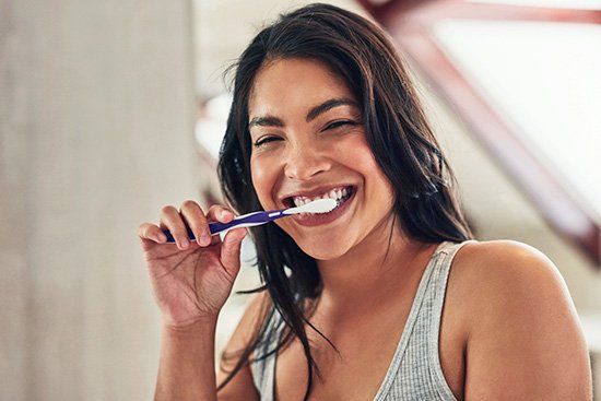 Gorgeous middle age Latina smiling while tooth brushing